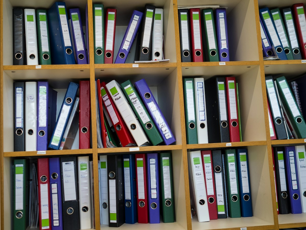 Étagères de bureau remplies de classeurs de couleur étiquetés à la main
